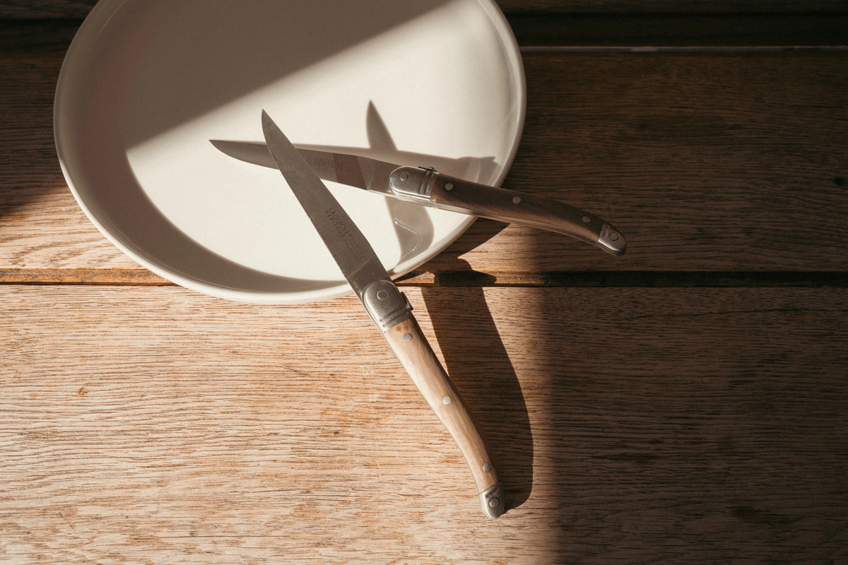 Deux couteaux de table Laguiole Héritage Médium manche bois, photo d'ambiance