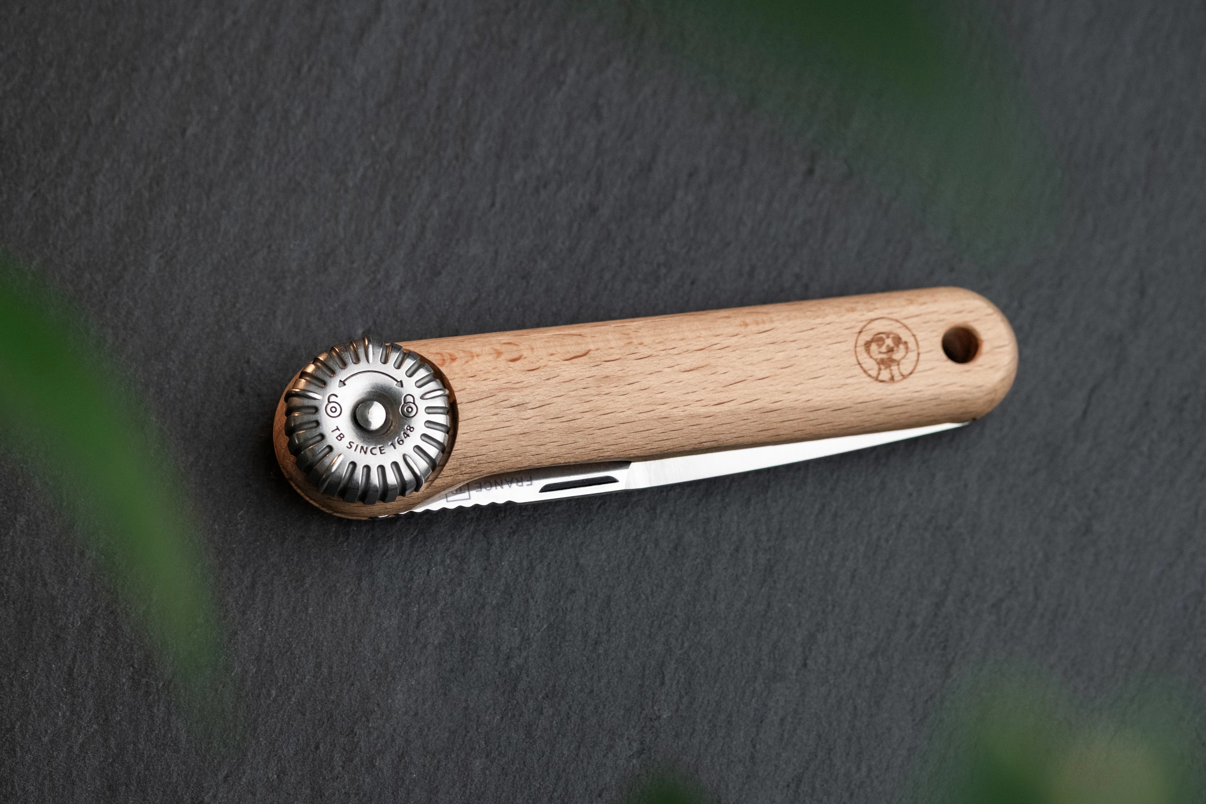 couteau suricate fermé avec onglier sur fond ardoise