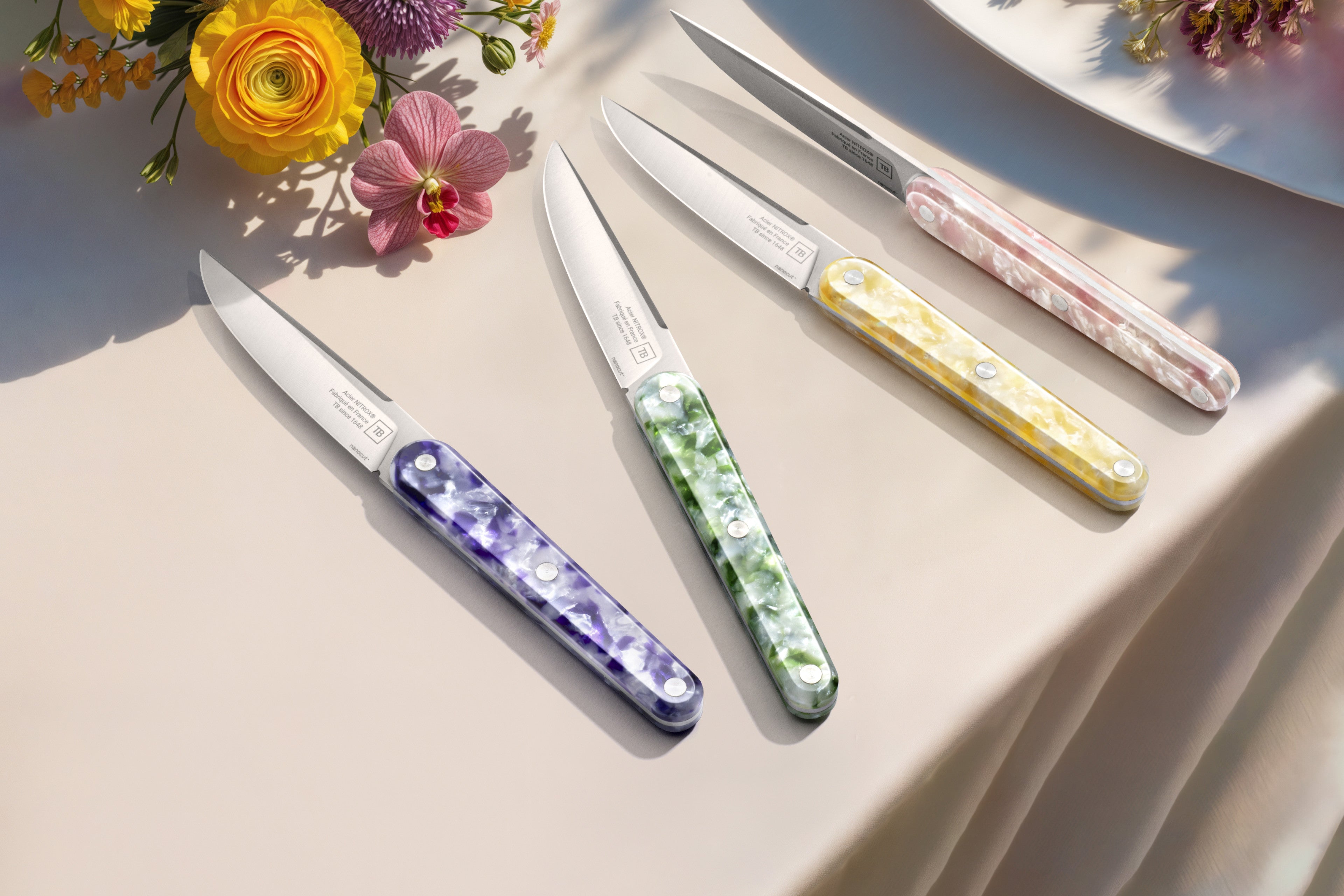 couteau Jospeh, coffret panaché sur une belle table, avec une nappe creme et bouquet de fleurs